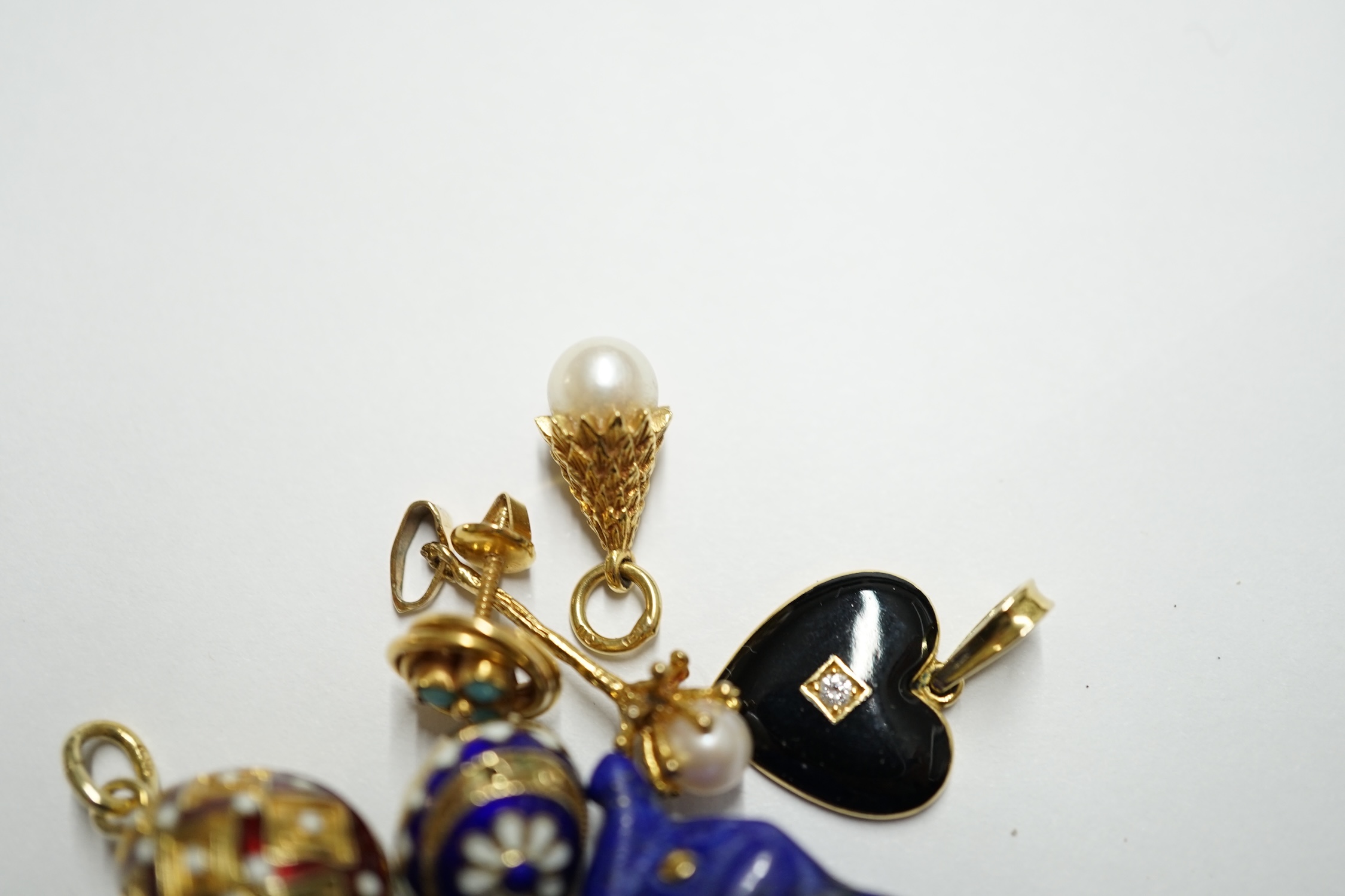 Two enamelled yellow metal and enamel egg pendants, one stamped 585, largest 15mm, a pair of Middle Eastern and yellow metal earrings and four assorted pendants. Condition - poor to fair